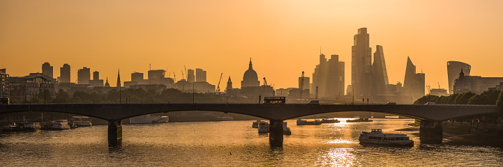 The futuristic skyscrapers along the River Thames and the historic dome of St. Paul’s Cathedral silhouetted at sunrise in the heart of London, UK.