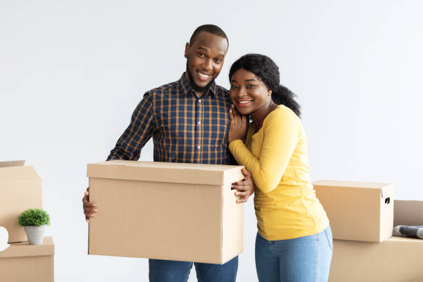 istock Cheerful Young African American Spouses Posing With Cardboard Boxes At Moving Day 1342213613