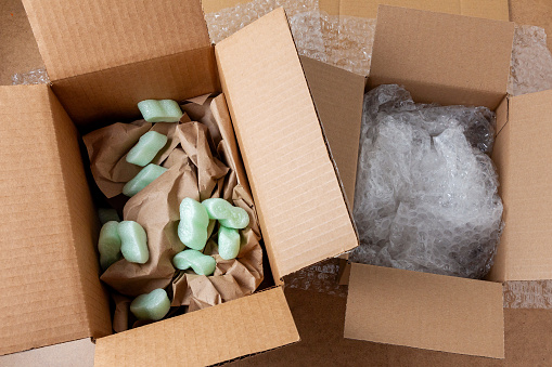 Cajas de cartón con relleno suave, plástico de burbujas y papel arrugado photo