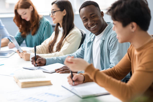 istock International group of students sitting at desk and talking 1342214782
