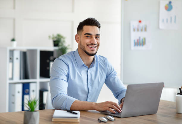 istock Attractive young Arab businessman using laptop pc at his desk in home office 1342216554