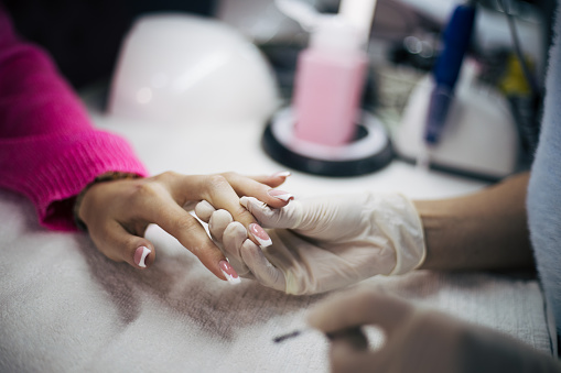 Close up of female hands having manicure spa treatment at beauty salon