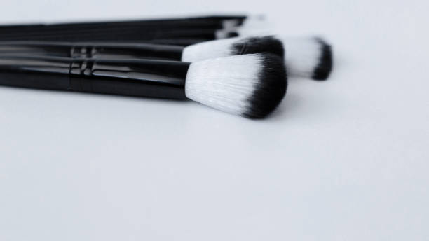 istock Black brushes with white and black pile for makeup of different sizes lie on a white background on top. top view, flat lay, copy space, isolate 1342218579