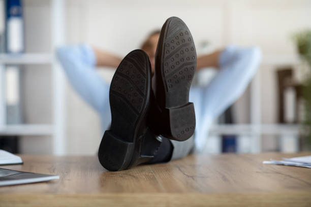 istock Millennial Arab office employee relaxing after work, putting legs on table at workplace, focus on feet 1342218599