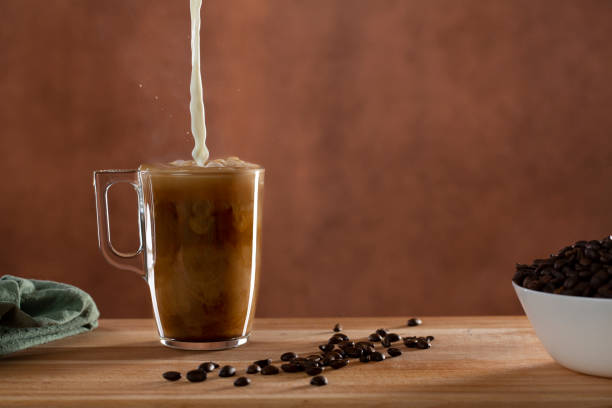 istock Coffee cup with cream milk splashing in it 1342220892