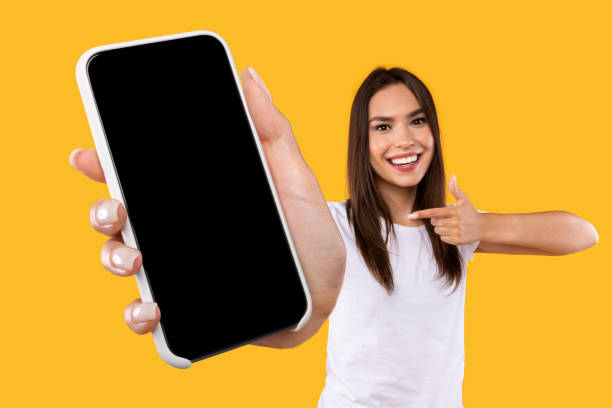 istock Woman showing white empty smartphone screen and pointing 1342221980