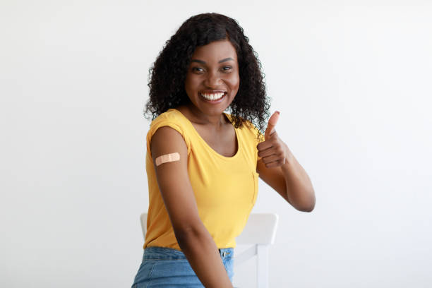 istock Vaccinated African Lady Gesturing Thumbs-Up Showing Arm Vaccination In Studio 1342222347