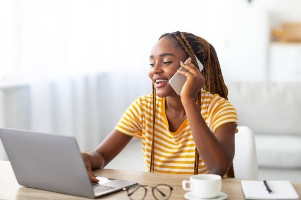istock Positive black woman freelancer talking on phone and using laptop 1342222467