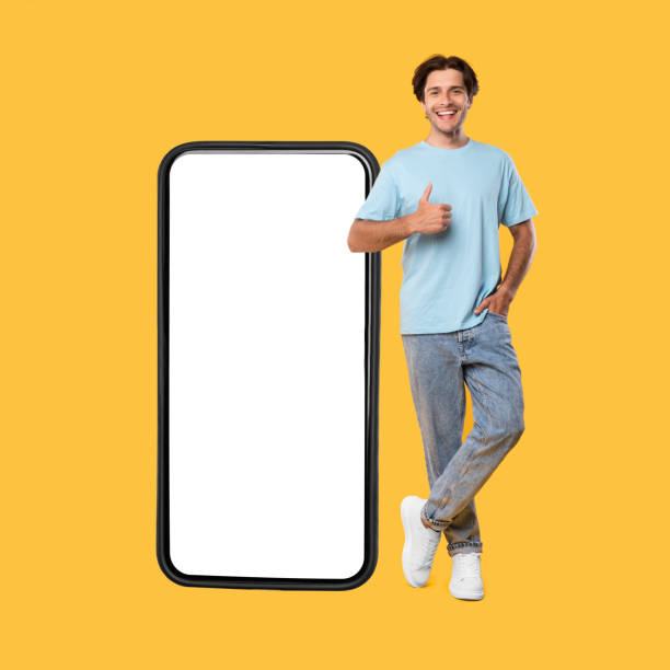istock Happy guy showing white empty smartphone screen and thumbs up 1342222474