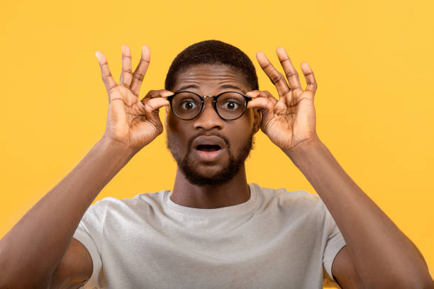 istock Emotional black guy touching his glasses, shouting WOW on yellow studio background, man overwhelmed with big sale 1342223204