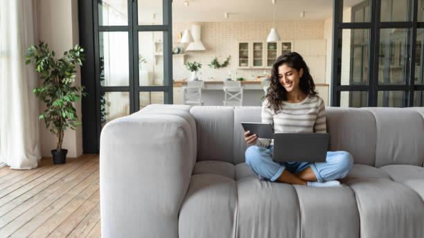 istock Happy Caucasian lady using laptop and tablet, studying or working remotely, having online conference at home, copy space 1342223429