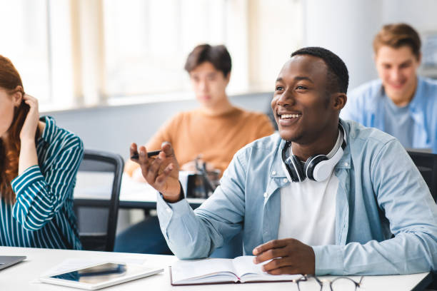 istock Smiling black student talking to teacher at classroom 1342223727