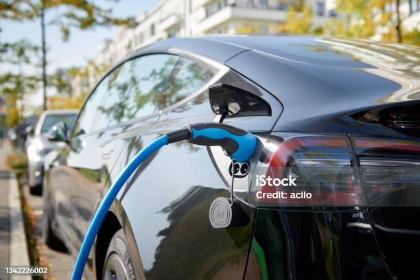 Black Tesla Model S Electric Car Connected To A Recharging Station Stock Photo - Download Image Now