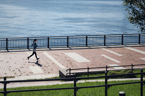 Young woman running on the seaside walkway