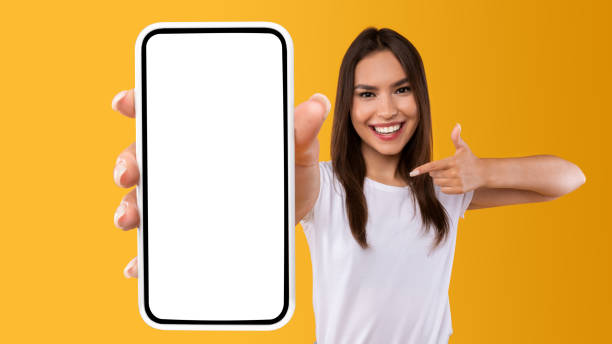 istock Woman showing white empty smartphone screen and pointing 1342226133