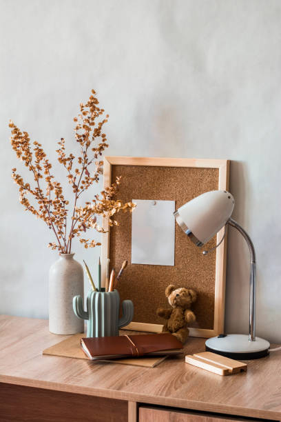 istock Back to school. The student's working home place. A table with educational supplies, a cork board for notes, a table lamp, pencils and a decorative vase with dried flowers 1342226219