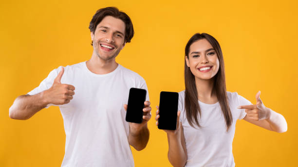 istock Couple showing blank empty smartphone screens for mockup 1342227019