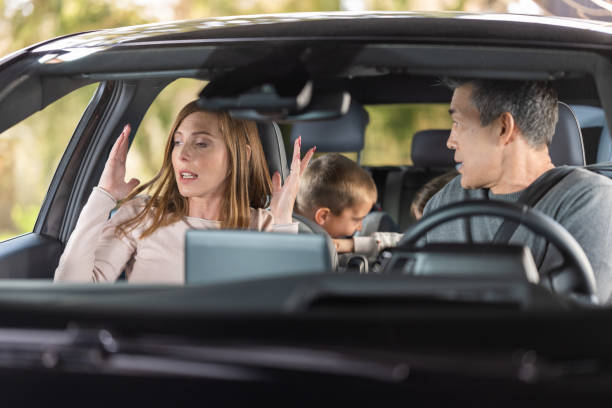 Frustrated parents arguing during trip by a car stock photo