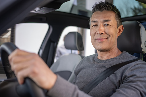 Portrait of smiling mature man driving his car.