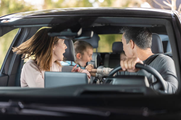 Children fighting in back seat of vehicle on road trip stock photo