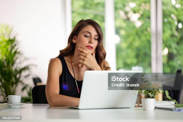 Young Woman Working On Computer In The Office Stock Photo - Download Image Now - Desk, Green Color, Adult