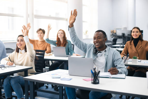 ritratto di persone diverse sorridenti che alzano le mani al seminario - corso di formazione foto e immagini stock