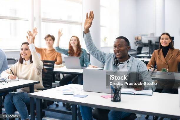 Portrait Of Smiling Diverse People Raising Hands At Seminar Stock Photo - Download Image Now