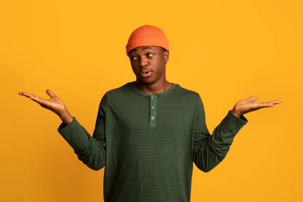 istock Making Choice. Pensive young black guy making scales with his empty hands 1342228594