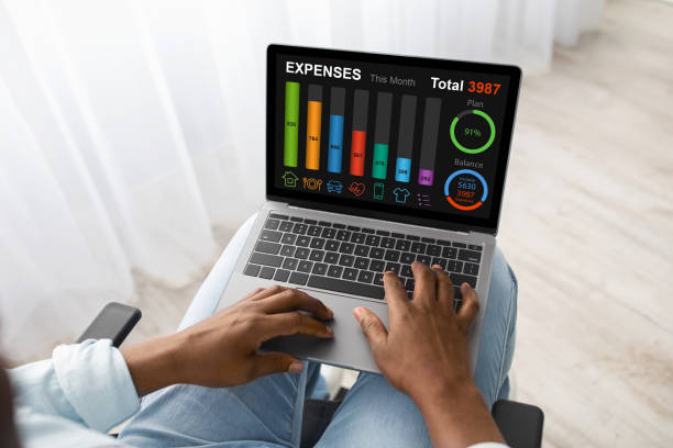 Man in wheelchair using laptop at home, planning budget