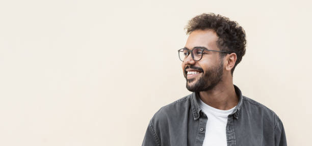 Handsome young man wearing glasses looking up stock photo