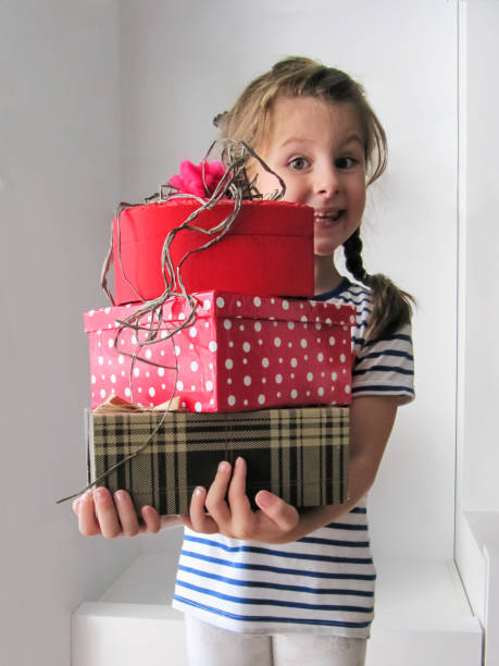 istock Little cute girl smiling and holding gift boxes 1342230572
