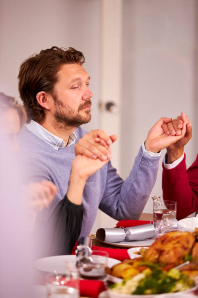 istock Multi Generation Family Hold Hands Around Table At Home Saying Grace Before Eating Christmas Meal 1342230615