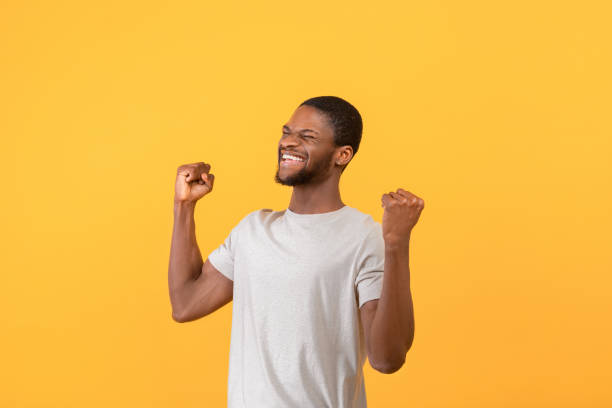istock Triumphant african american man screaming in excitement, gesturing YES with both hands over yellow background 1342230623