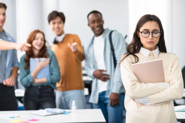 People mocking and making fun of sad woman Group Conflict. Sad latin woman in eyeglasses standing away alone, suffering humiliation and public disgrace, crowd of bad people bullying pointing fingers at victim, laughing. Discrimination, Gossip gossip stock pictures, royalty-free photos & images