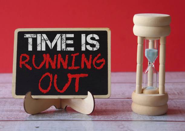 TIME IS RUNNING OUT written on blackboard