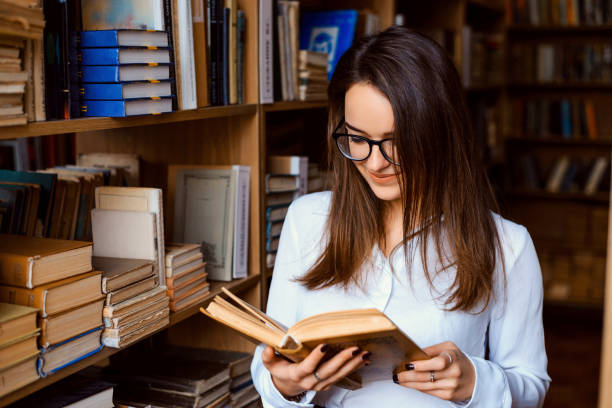 istock Young attractive university student reading a book in library 1342233589