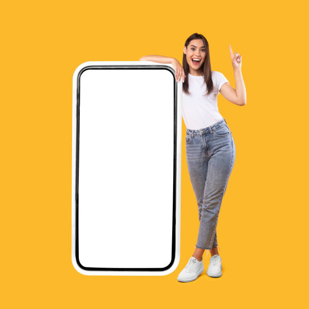 istock Woman showing white empty smartphone screen and pointing up 1342234941