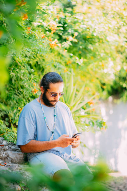 istock Young Man Texting on a Smartphone on the Street 1342235023