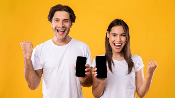 istock Couple showing two black empty smartphone screen and gesturing yes 1342235312