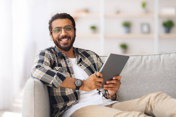 istock Handsome indian man chilling at home with digital tablet 1342235689