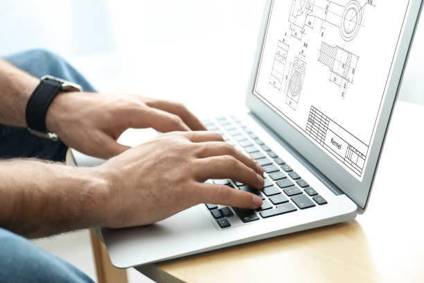 istock Male engineer working with technical drawing on laptop at table, closeup 1342236282