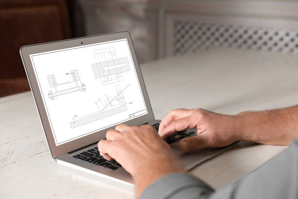 istock Male engineer working with technical drawing on laptop indoors, closeup 1342236284