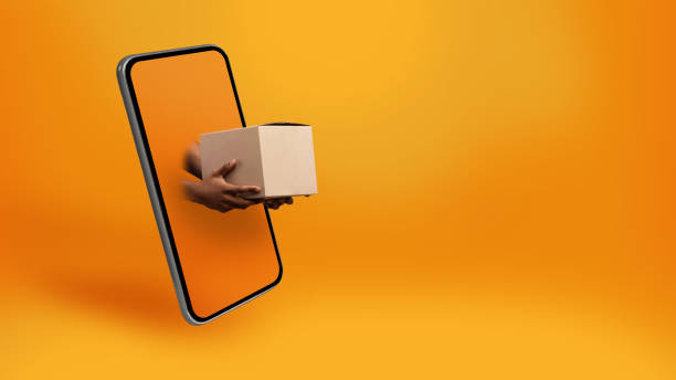 istock African Courier's Hands Giving Box From Smartphone Screen, Yellow Background 1342236851