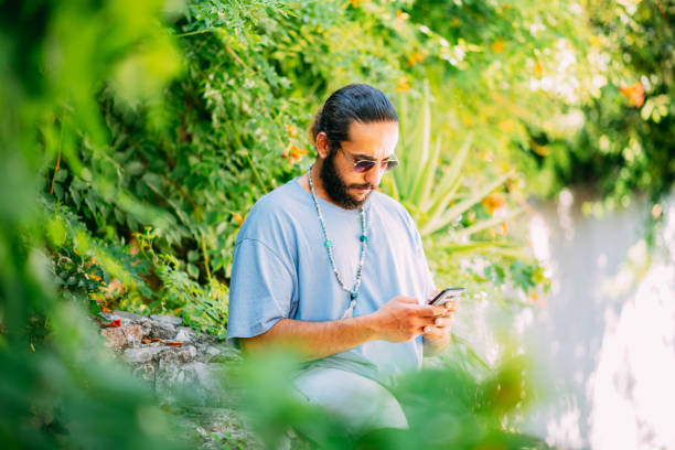 istock Young Man Texting on a Smartphone on the Street 1342236994