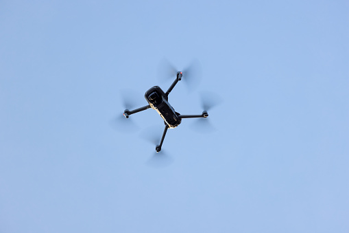 Hamburg, Germany - September 09, 2021: Close up of Camera Drone Dji Mini 2 on the blue sky -   View from below