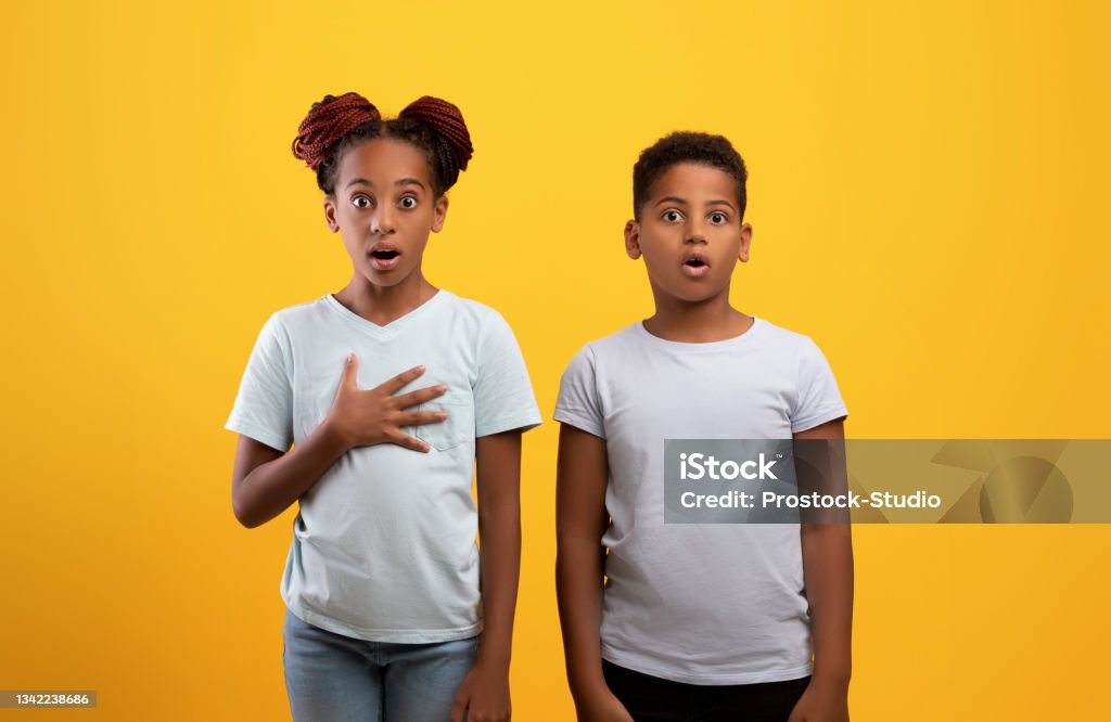 Verblüffter Afroamerikanischer Bruder Und Schwester Auf Gelb Stockfoto