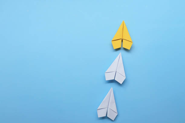 istock yellow paper plane is leadership with white paper plane 1342239541