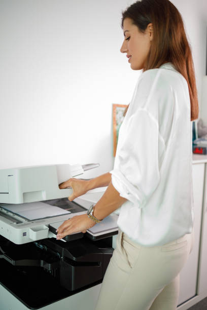istock Female assistant photocopying documents on machine in the office 1342239565