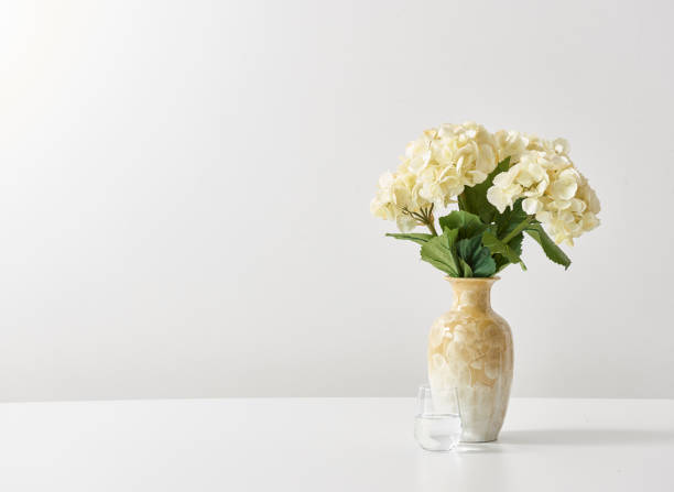 istock white background and flower vase book wood table 1342239838