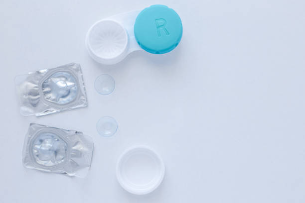 A container for lenses, two sealed lenses and lenses lying on a table